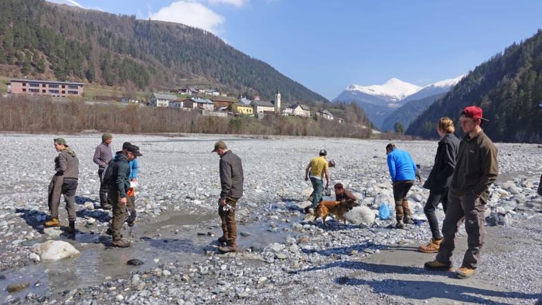 Menschen suchen im Flussbett nach Müll